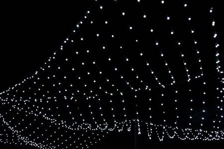 Christmas garland bright white against black sky Christmas New year holiday contrastの写真素材