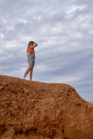 Girl standing on a cliff orange tone