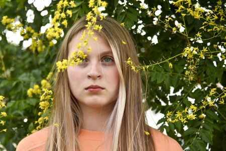 Portrait of a girl under a flowering tree yellowの写真素材