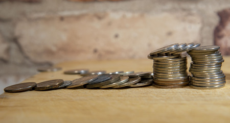 Stacks of coins and a vintage brick wallの写真素材
