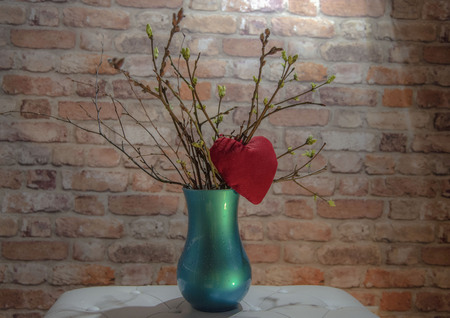 Red heart on spring blossoming flowersの写真素材