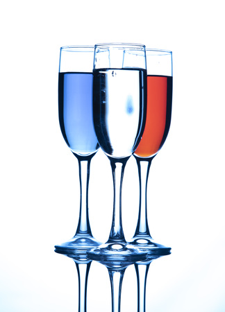 Three glasses of champagne, with liquid of different colors, on a white background.の写真素材