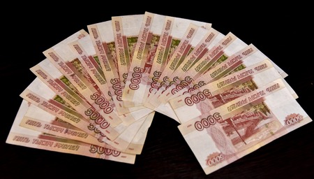 Five thousand bills lie on the black table, and part of the money in women's hands. Blackの写真素材