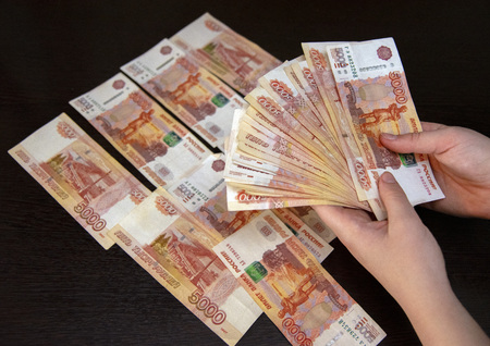 Five thousand bills lie on the black table, and part of the money in women's hands.の写真素材