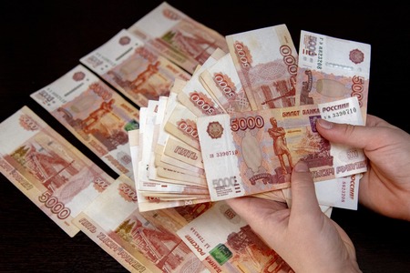 Five thousand bills lie on the black table, and part of the money in women's hands.の写真素材