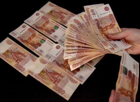 Five thousand bills lie on the black table, and part of the money in women's hands.の写真素材
