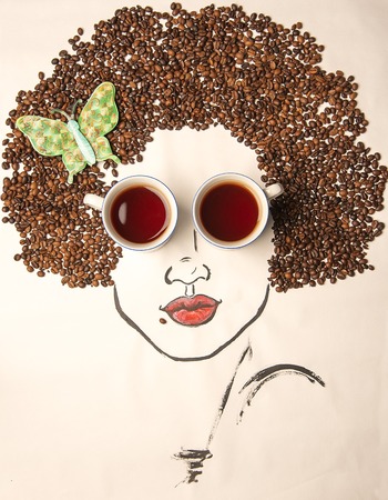 Conceptual photography. The painted face of the girl, complemented by cups of coffee instead of glasses, and hair made of coffee beans.の写真素材
