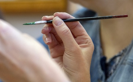 Drawing lesson at school.Children's hands holding a brushの写真素材