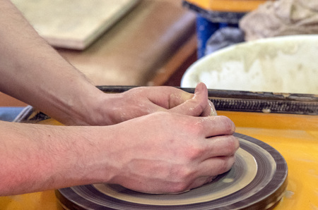 Master class on making a ceramic pot with a Potters wheel. The pottery is rotating around its axis.の写真素材