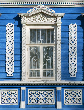 The blue wall of the house with Windows and beautiful carved wooden frames.の写真素材