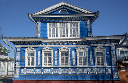 The blue wall of the house with Windows and beautiful carved wooden frames.の写真素材