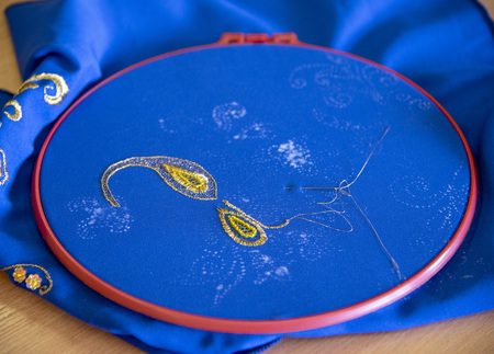 Master class on embroidery.The patterned gold thread on a blue background.の写真素材