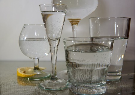Different glasses are on the table, filled with clean water.Next slice of lemon.の写真素材