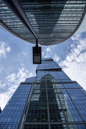 Fragments of skyscrapers against the blue sky and flying clouds. Architectural style - modernism.の写真素材