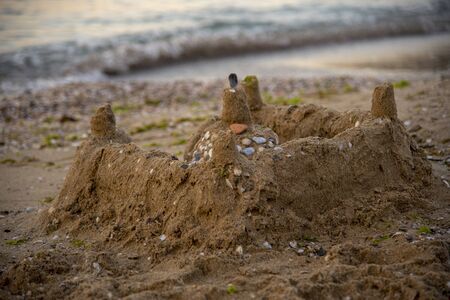Sand castle, decorated with shells, on the beach. Photographed at dawn this morning.の写真素材