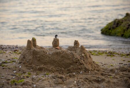 Sand castle, decorated with shells, on the beach. Photographed at dawn this morning.の写真素材