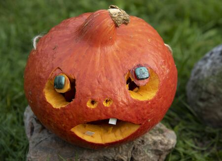 Orange Halloween pumpkin with carved eyes, nose and mouthの写真素材