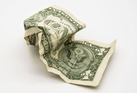 One old crumpled dollar on a light gray background.の写真素材