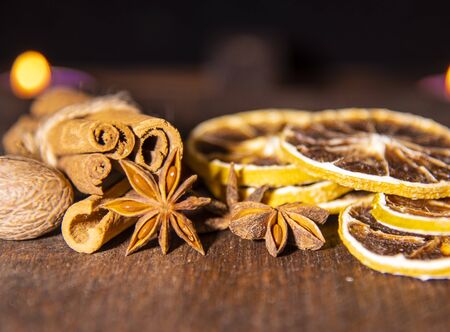 Various flavorful seasonings on a textured wooden surface on a blurred background.Cinnamon, star anise and citrus.の写真素材