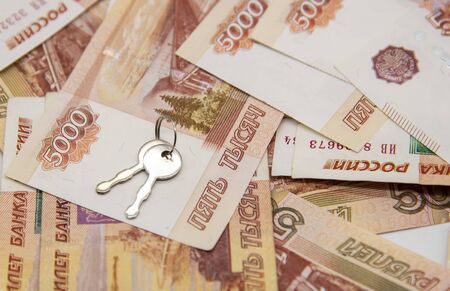 A metal key on five-thousand-ruble notes. Concept photo as a symbol of improving living conditions, buying or renting a home.の写真素材