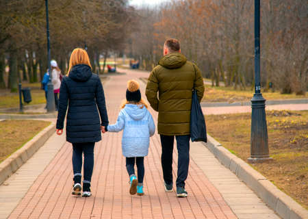 Mom, dad and daughter are photographed from the back.のeditorial素材