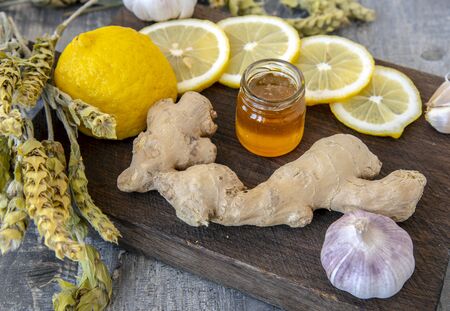 Ginger, lemon, garlic and mountain Mursal tea on a rough wooden Board.
