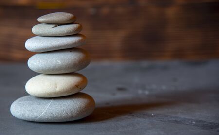 A pyramid of smooth sea stones on a gray tabletop.