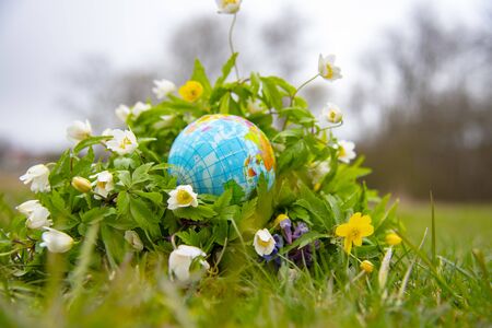 The globe is surrounded by bright spring flowers.の写真素材