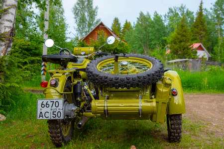 Russia, Moscow region, June 2020. Restored green retro motorcycle with sidecar on the background of nature.のeditorial素材