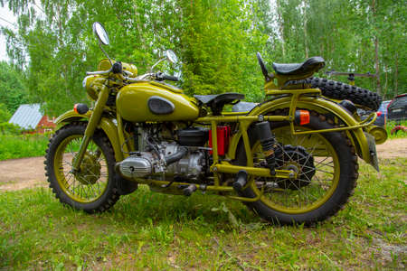 Russia, Moscow region, June 2020. Restored green retro motorcycle with sidecar on the background of nature.のeditorial素材