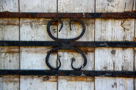An ornament of rusty metal parts on a wooden gate.の写真素材