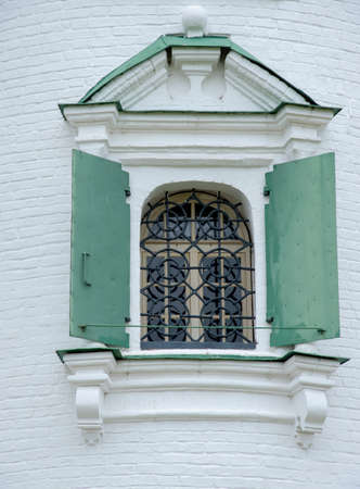 A barred window with beautiful architraves against a white brick wall. Architectural Details and elementsの写真素材