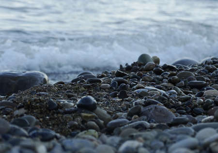 Wet sea pebbles and water spray close-up. Abstract background, design.