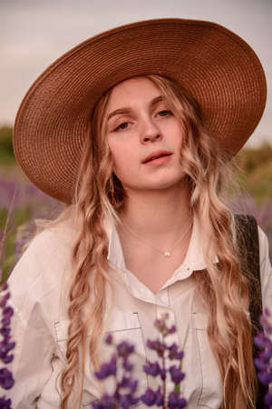 Large portrait of a charming blonde girl in a hat and white shirt .の写真素材