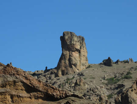 A rock against a bright blue sky.の写真素材