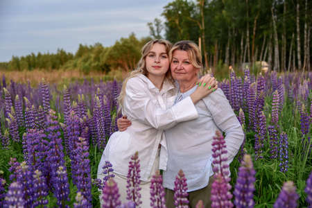 A grandmother and a teenage granddaughter in light clothing .の写真素材