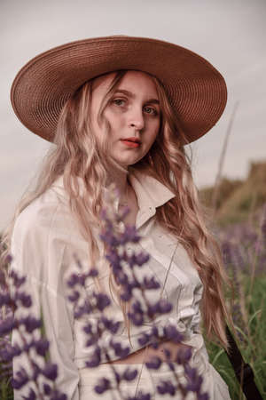 Large portrait of a charming blonde girl in a hat and white shirt .の写真素材