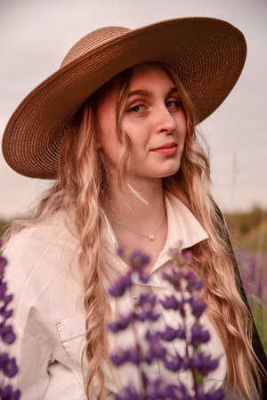 Large portrait of a charming blonde girl in a hat and white shirt .の写真素材