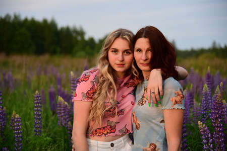 Daughter and mother posing in Lupin fields in the last rays of the sun.の写真素材