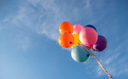 Bright balloons with the inscription in Russian Happy Birthday on the background of a bright blue sky. Festive background.の写真素材