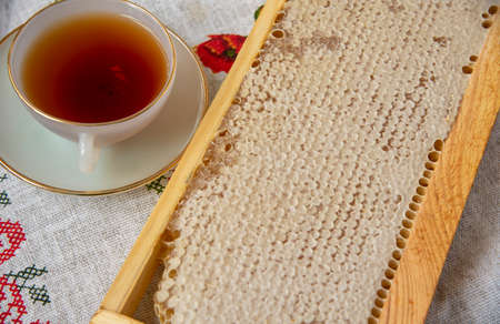 Honey combs and a Cup of tea on a linen tablecloth. Photographed from above, the concept of healthy eating.の写真素材