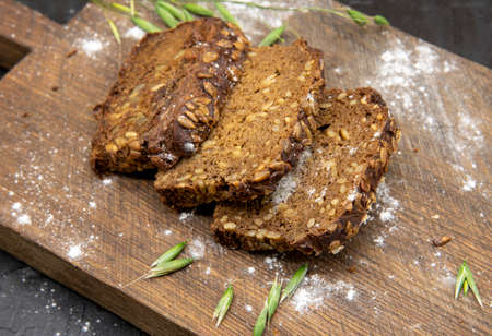 Fitness bread with seeds, cut into pieces, lies on a wooden Board.の写真素材