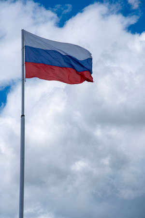 Russian tricolor flag waving in the wind against a cloudy sky.Vertical photo.の写真素材
