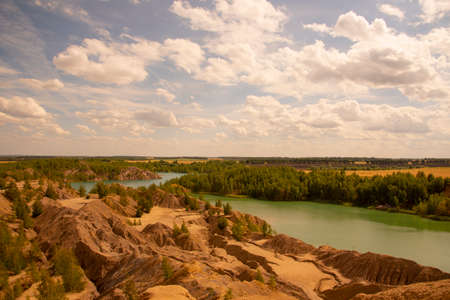 Summer landscape.Relief clay mountains and a bright green lake.の写真素材
