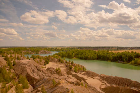 Summer landscape.Relief clay mountains and a bright green lake.の写真素材