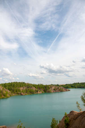 Bright summer landscape. Blue lake among the sand hills on the textured background of the cloudy sky.の写真素材