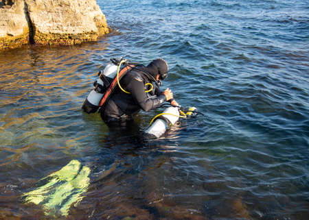 Crimea, Cape Tarkhankut, August 2020 Diving training. People in wetsuits and scuba gear are preparing to dive into the water.のeditorial素材