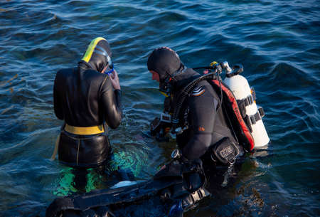Crimea, Cape Tarkhankut, August 2020 Diving training. People in wetsuits and scuba gear are preparing to dive into the water.のeditorial素材