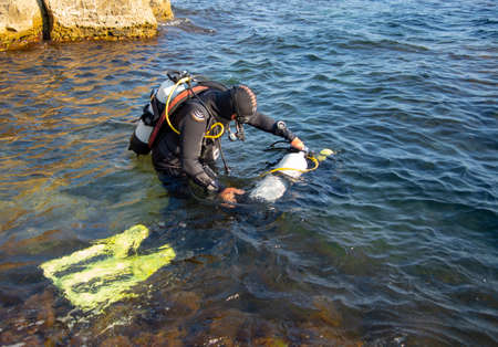 Crimea, Cape Tarkhankut, August 2020 Diving training. People in wetsuits and scuba gear are preparing to dive into the water.のeditorial素材