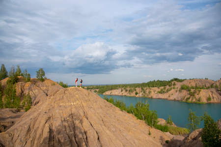 Blue lake among the sand hills on the textured background of the cloudy sky.の写真素材